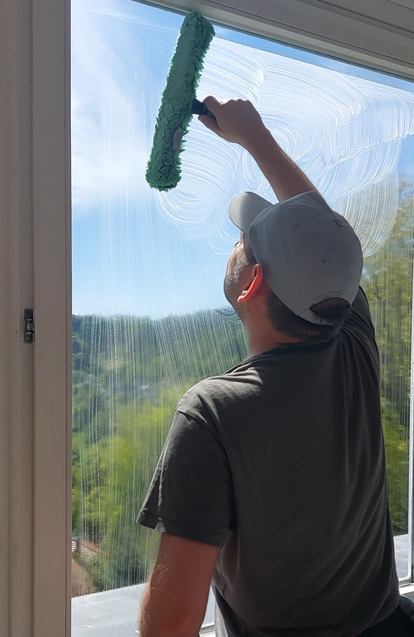 Das Foto zeigt einen Fensterputzer bei der Fensterreinigung